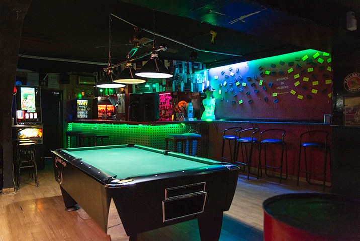 Sala Red en Barcelona, bar con mesa de billar, barra iluminada en verde, taburetes altos y ambiente de pub