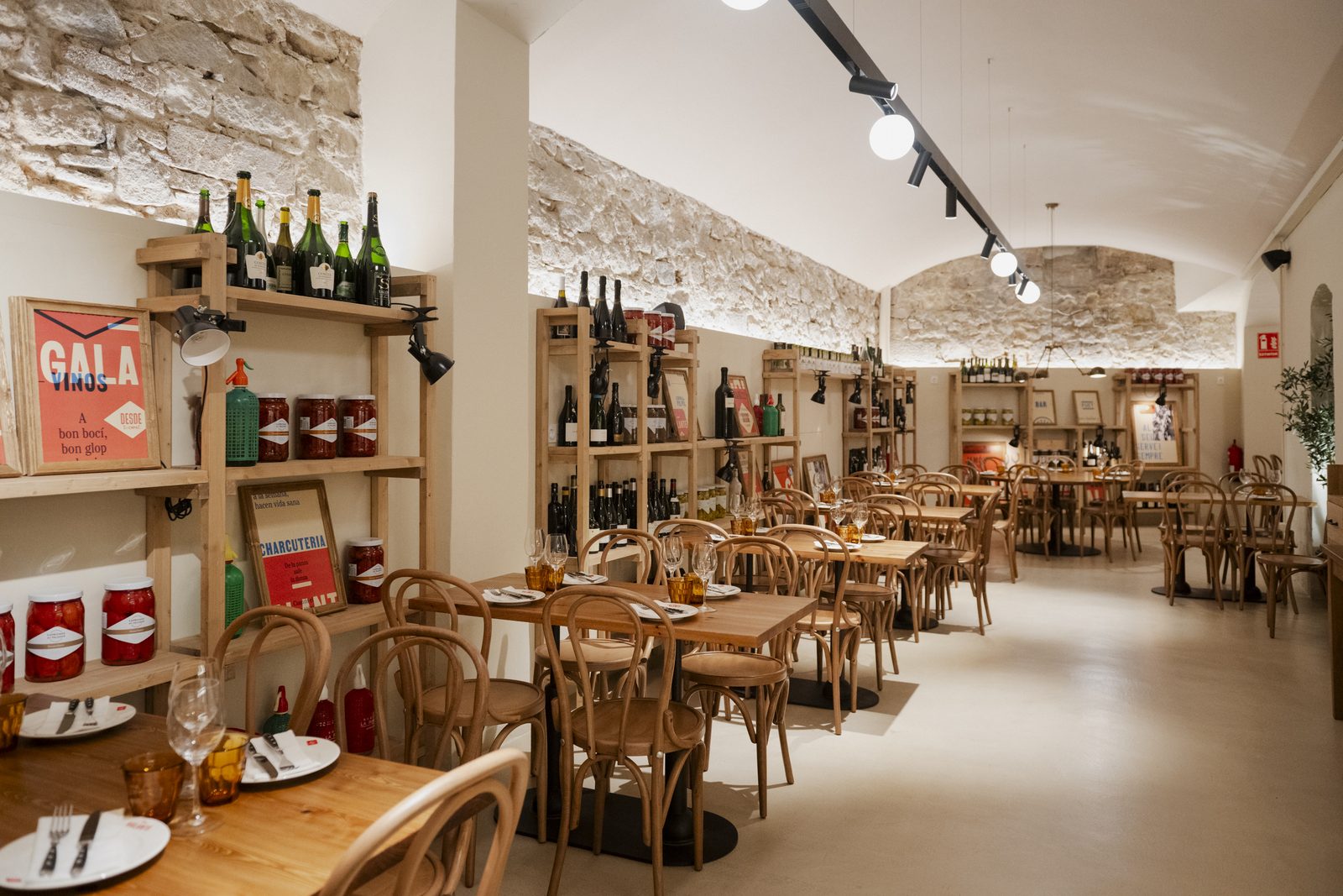 Sala Gala en Barcelona, comedor con pared de piedra vista, mesas de madera y ambiente luminoso